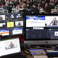 Blick über die Schulter der Technik beim Zulieferertag Automobilwirtschaft BW 2021, auf mehreren Bildschirmen wird das Streaming organisiert.