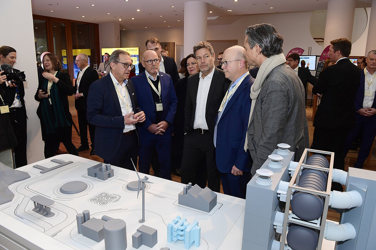 Verkehrsminister Winfried Hermann und Bundeswirtschaftsminister Robert Habeck unterhalten sich am Stand Direct Air Capture (DAC) aus BW. 