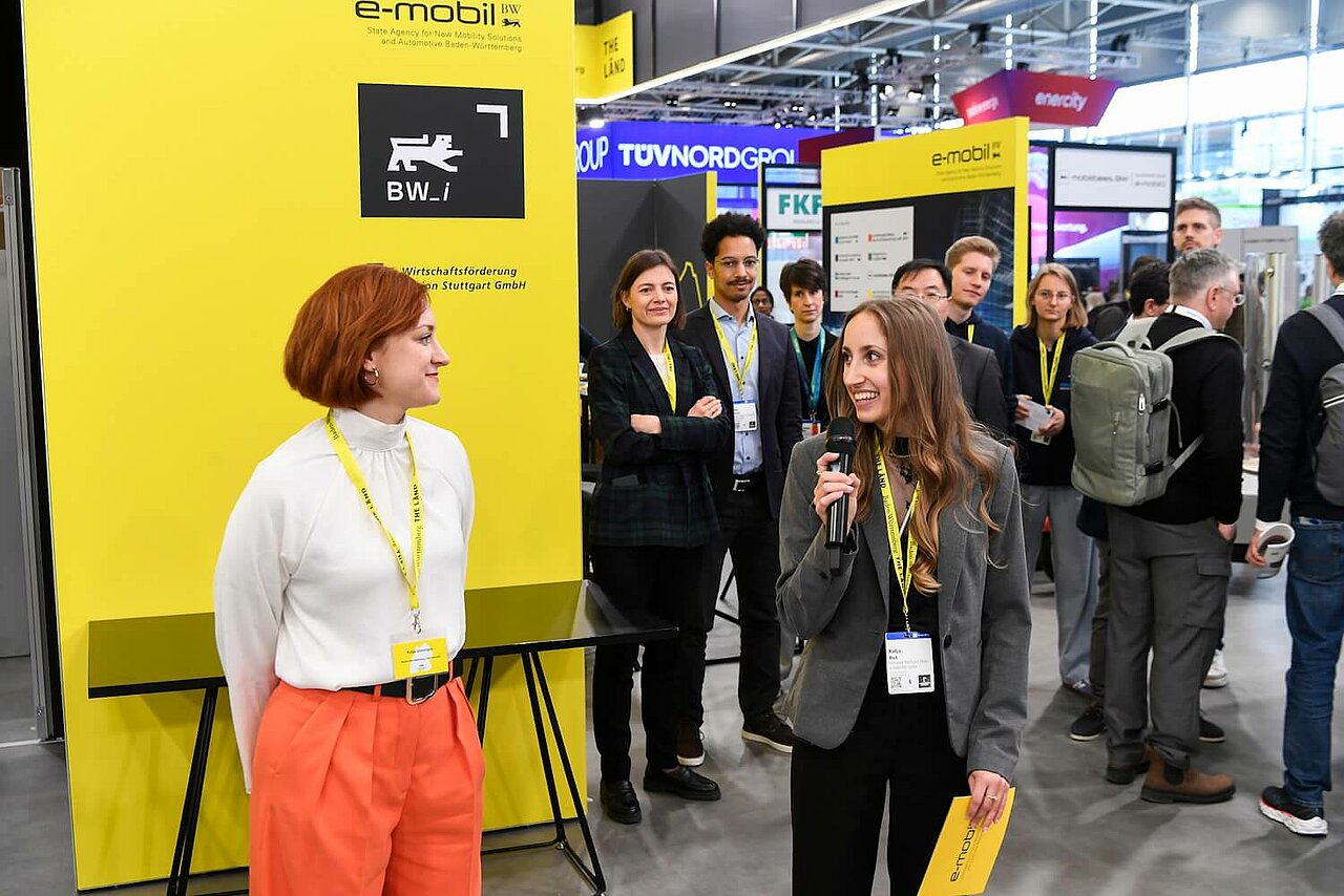 Eine Mitarbeiterin von Baden-Württemberg International (bw_i) und eine Mitarbeiterin von e-mobil BW eröffnen den Baden-Württemberg Pavillon auf der Hannover Messe 2025.