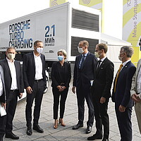 Die Teilnehmenden der Zwischenbilanzkonferenz des Strategiedialogs Automobilwirtschaft BW 2020 vor dem Turbo-Charging-Truck von Porsche. 