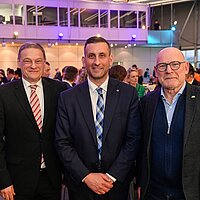 Franz Loogen, Raed Kadri und Winfried Hermann blicken in die Kamera.