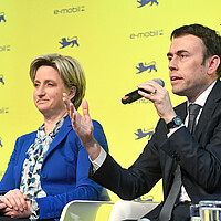 Dr. Nils Schmid MdB und Wirtschaftsministerin Dr. Nicole Hoffmeister-Kraut MdL auf dem Podium. Dr. Nils Schmid spricht in ein Mikrofon und hält die Hand hoch.