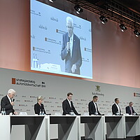 Die Teilnehmenden der Pressekonferenz stehen auf der Bühne.