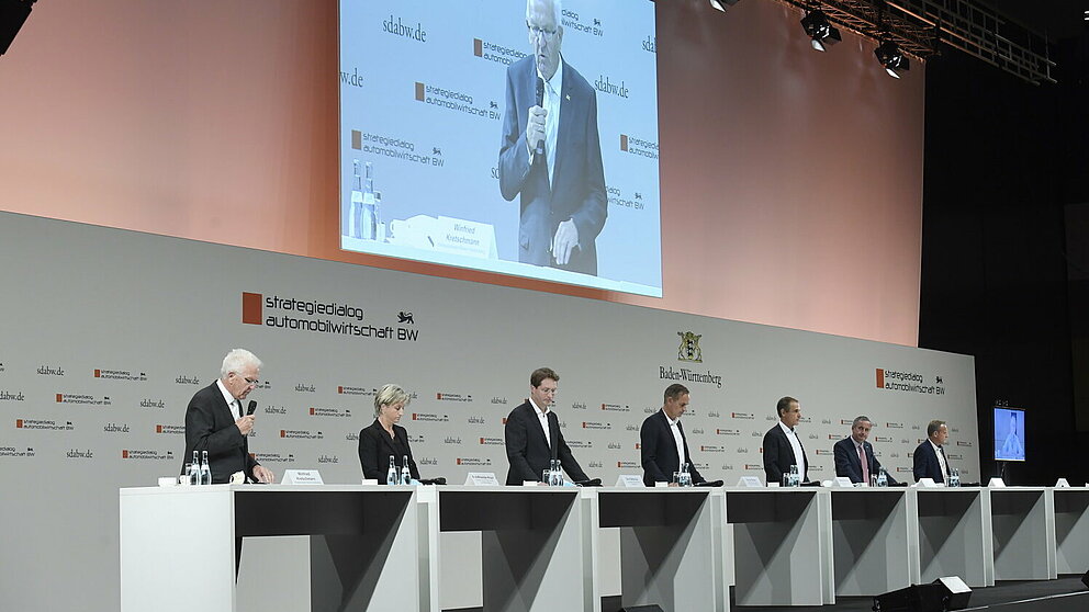 Die Teilnehmenden der Pressekonferenz stehen auf der Bühne.