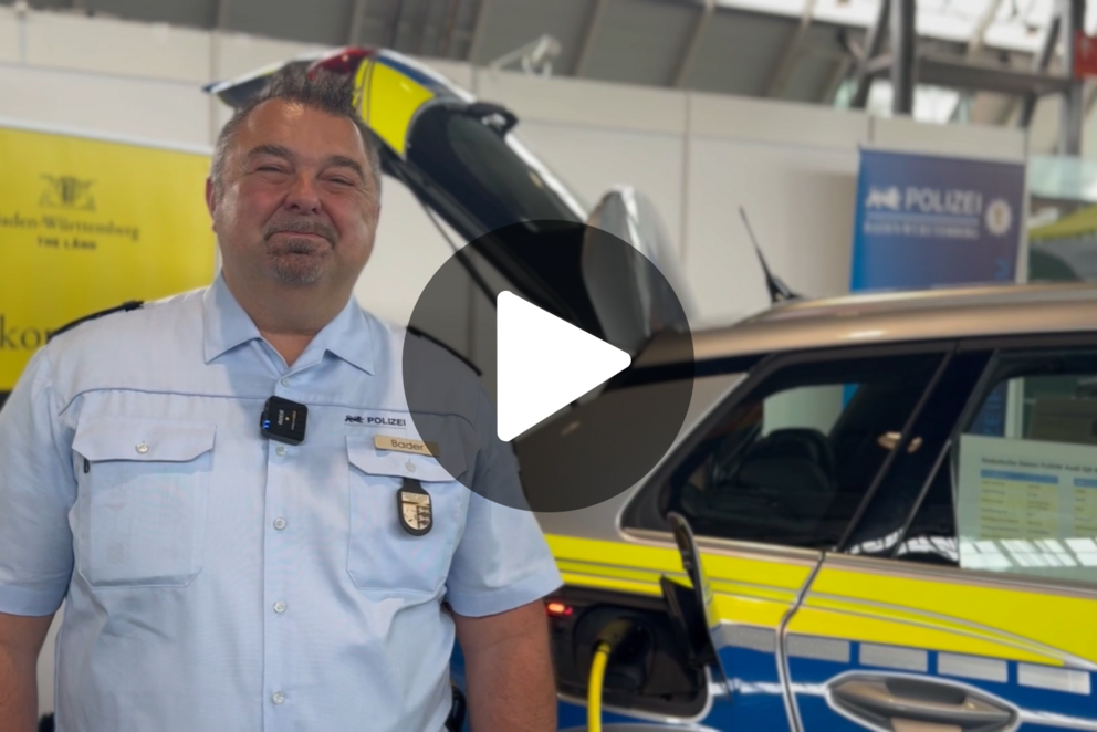 Erster Polizeihauptkommissar Markus Bader steht vor einem Elektrostreifenwagen der Polizei BW