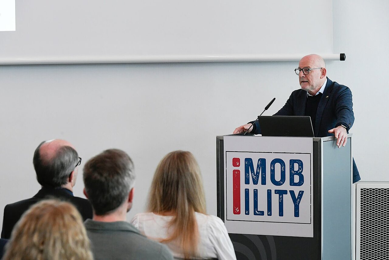 Verkehrsminister Winfried Hermann auf dem Podium bei der i-Mobility 2025.