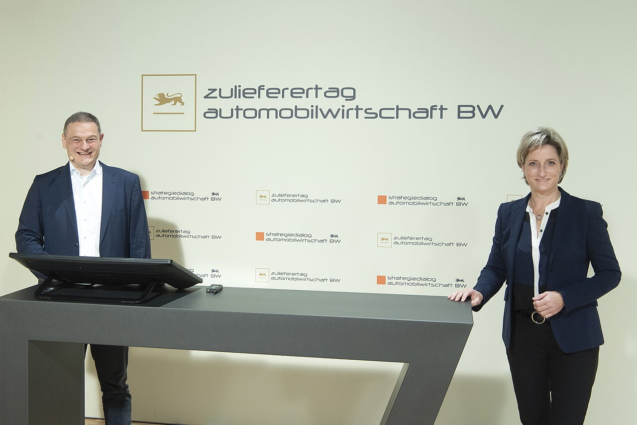 Links e-mobil BW Geschäftsführer Franz Loogen, rechts Wirtschaftsministerin Dr. Nicole Hoffmeister-Kraut, hinter Ihnen ist eine Wand mit dem Strategiedialog Automobilwirtschaft BW zu sehen. 