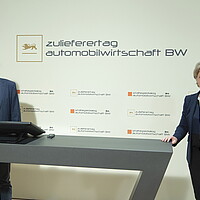 Links e-mobil BW Geschäftsführer Franz Loogen, rechts Wirtschaftsministerin Dr. Nicole Hoffmeister-Kraut, hinter Ihnen ist eine Wand mit dem Strategiedialog Automobilwirtschaft BW zu sehen. 
