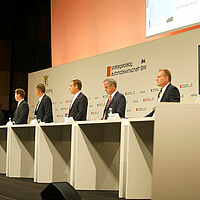 Experten aus Politik, Wirtschaft, Wissenschaft, Arbeitnehmerverbänden, Verbraucherorganisationen und Umweltverbänden stehen auf der Bühne bei der SDA-Jahresveranstaltung.