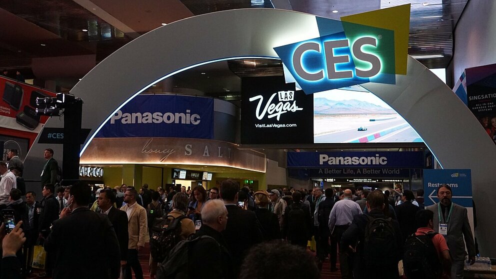 Messebogen zur CES 2020 in Las Vegas. Unter dem Bogen schlendern viele Besuchende über die Messe.