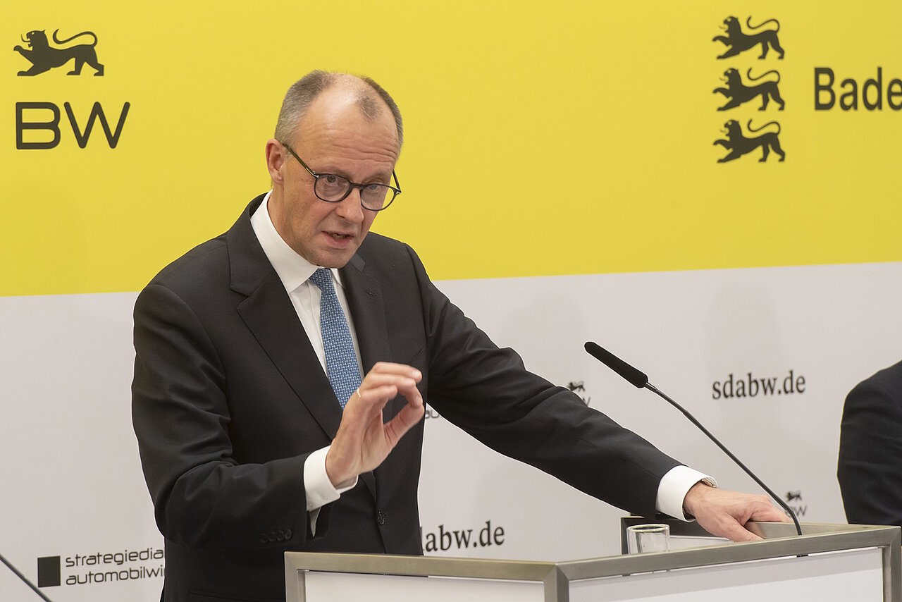 Bundeskanzler Friedrich Merz bei der Pressekonferenz des Strategiedialog Automobilwirtschaft BW vor einer gelben Wand.
