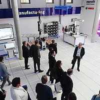 Eine Besuchergruppe lauscht einem Vortrag in einem Vorführraum.