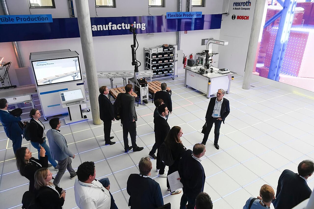 Eine Besuchergruppe lauscht einem Vortrag in einem Vorführraum.