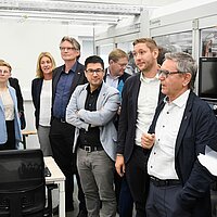 Eine Personengruppe in einem kleinen Forschungslabor.