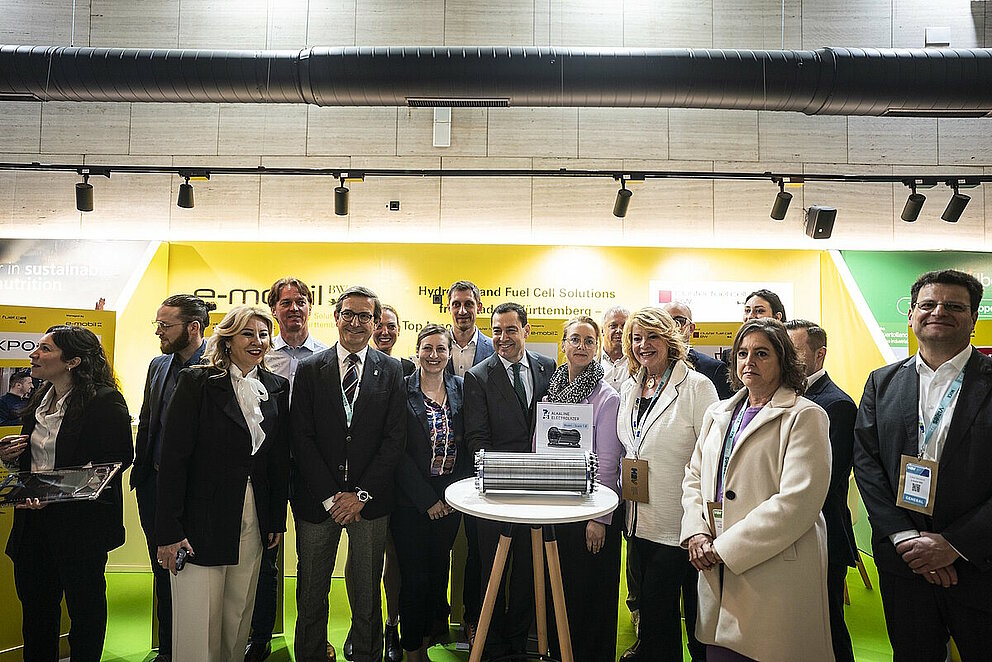 Hochranginge Politikerinnen und Politiker sowie Mitarbeiterinnen und Mitarbeiter der e-mobil BW an einem Messestand auf dem spanischen Wasserstoff-Kongress in Huelva..