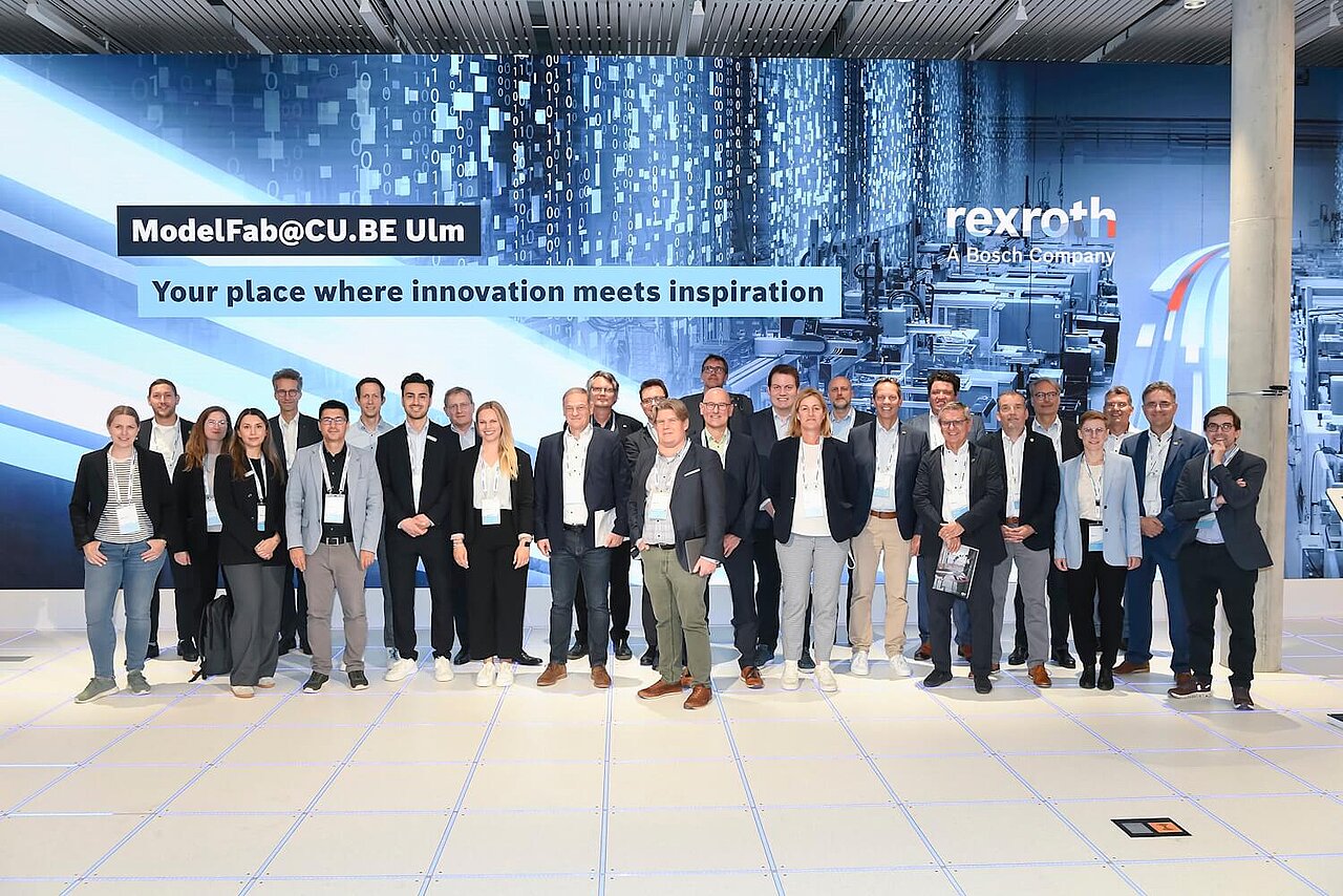 Gruppenbild vor großer LED-Wand.