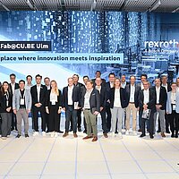 Gruppenbild vor großer LED-Wand.