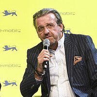 Dr. Stefan Wolf, Vorsitzender des Vorstands der ElringKlinger AG spricht in ein Mikrofon auf dem Podium.