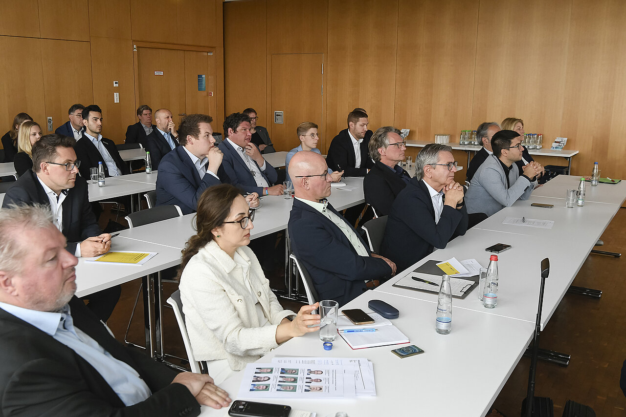 Eine Gruppe von Menschen in einem Seminarraum.