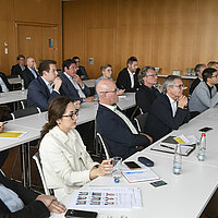 Eine Gruppe von Menschen in einem Seminarraum.