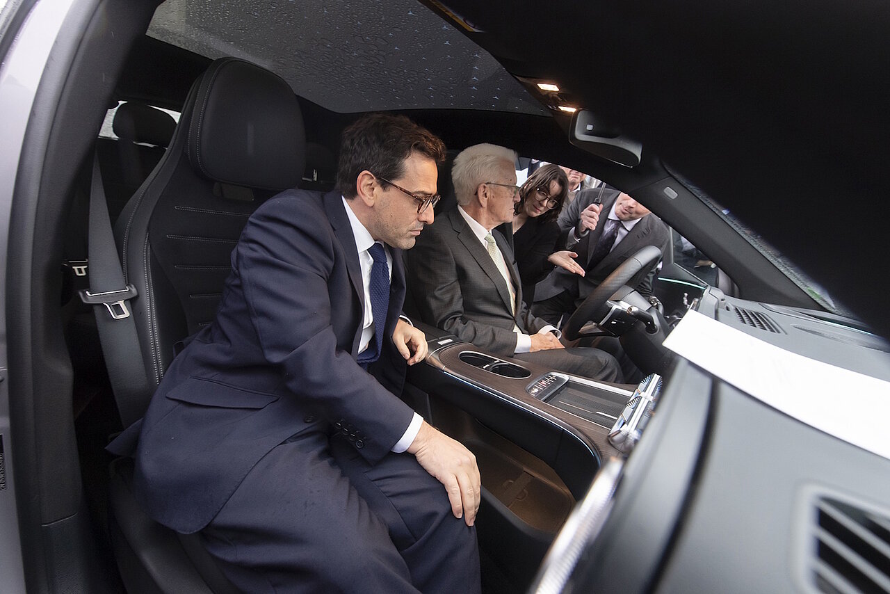 EU-Vizepräsident Stéphane Séjourné und Winfried Kretschmann sitzen im Ausstellungsfahrzeug bei der SDA-Jahresveranstaltung.