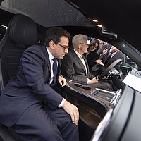 EU-Vizepräsident Stéphane Séjourné und Winfried Kretschmann sitzen im Ausstellungsfahrzeug bei der SDA-Jahresveranstaltung.