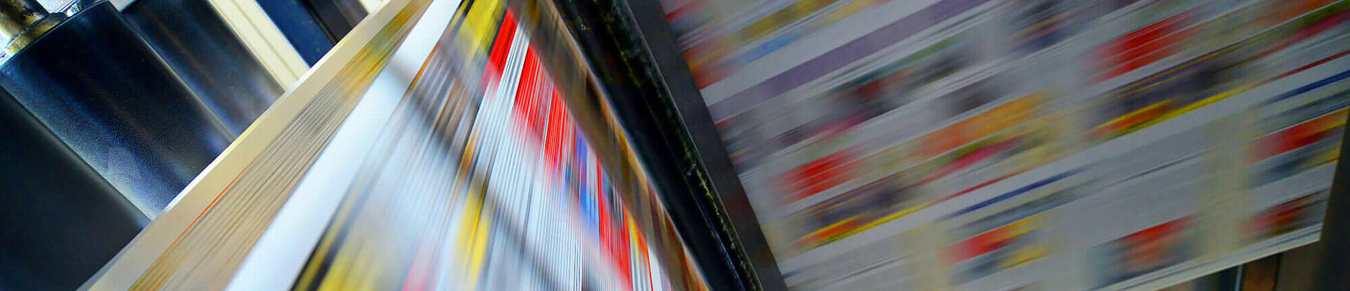 Druckpapier einer Zeitung läuft über eine Walze.