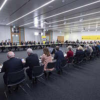 Impressionen vom Top-Level-Meeting beim Strategiedialog Automobilwirtschaft BW, alle Teilnehmenden sitzen in einem Konferenzraum