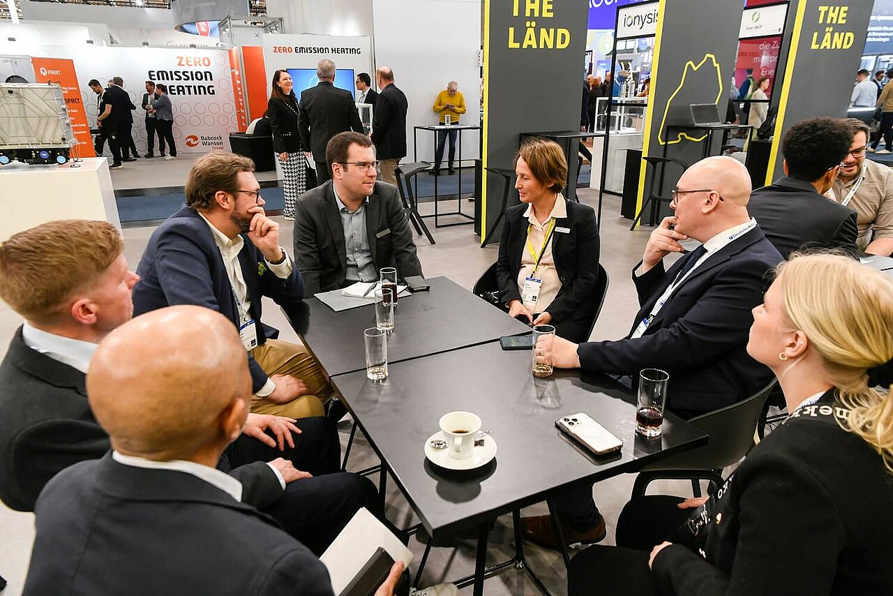 Ein Mitarbeiter und eine Mitarbeiterin sitzen am Tisch mit der finnischen Wirtschaftsförderung LADEC Lahti Region Development auf der Hannover Messe 2025.