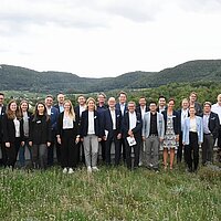 Gruppenfoto mit grünem Hintergrund.