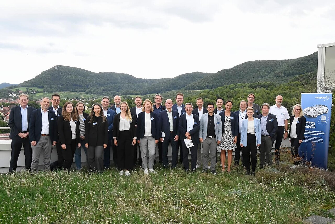Gruppenfoto mit grünem Hintergrund.