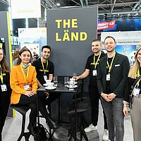 Sechs Mitarbeiterinnen und Mitarbeiter von e-mobil BW am Messestand des Baden-Württemberg Pavillons auf der Hannover Messe 2025.