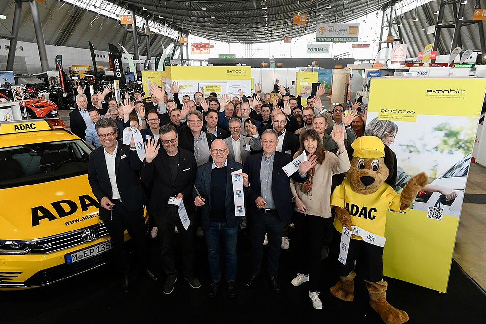 Gruppenfoto auf der i-Mobility 2025. Der Stand wird eröffnet.