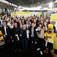 Gruppenfoto auf der i-Mobility 2025. Der Stand wird eröffnet.