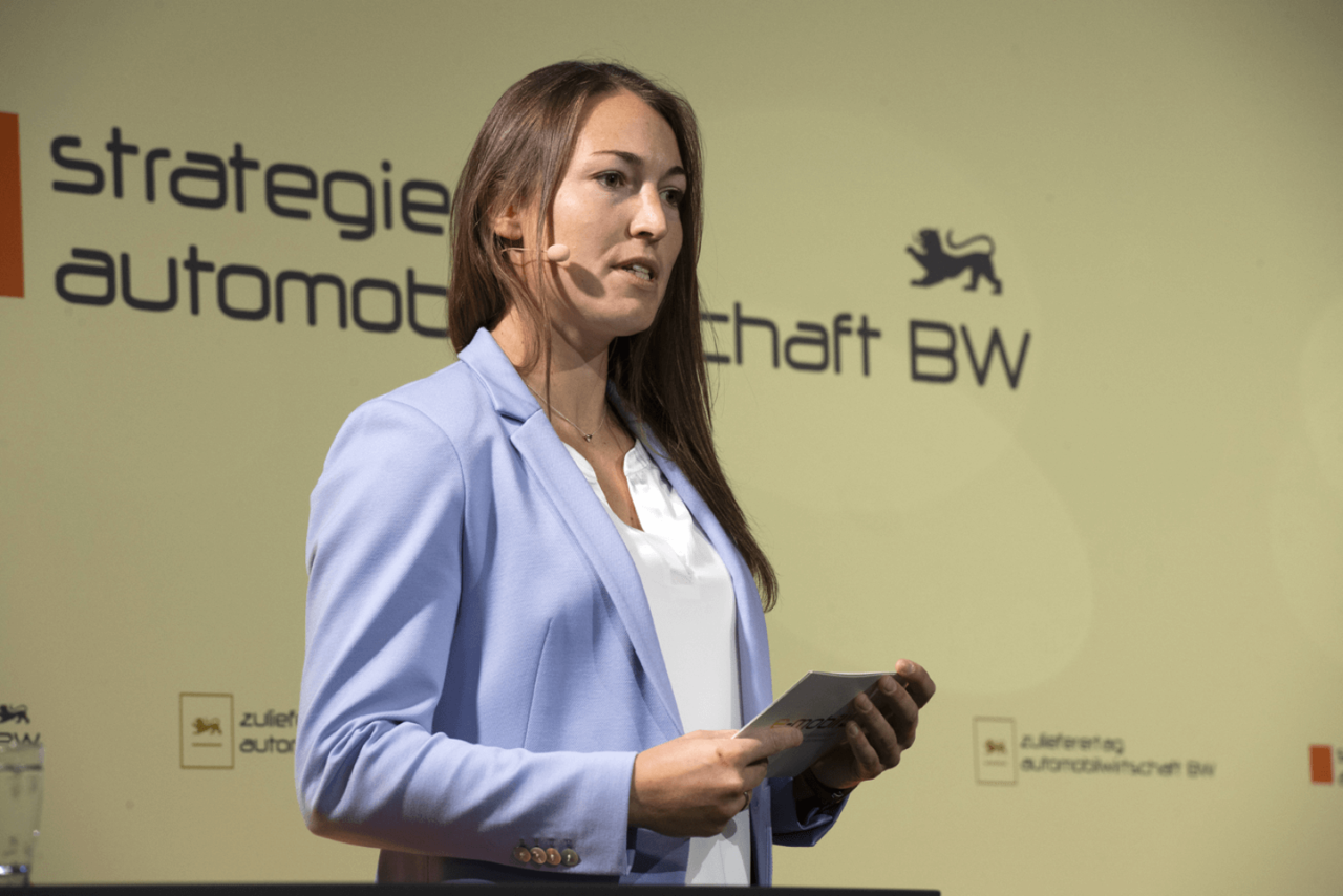 Saskia Schuettke mit einem Mikrofon auf dem Zulieferertag Automobilwirtschaft BW 2021.